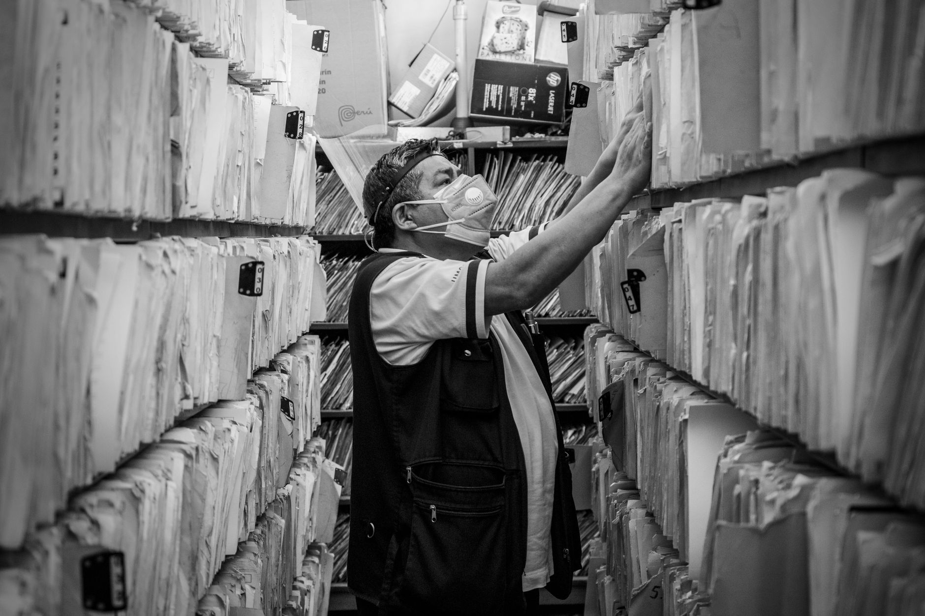 A man sorting through files in an archive aisle